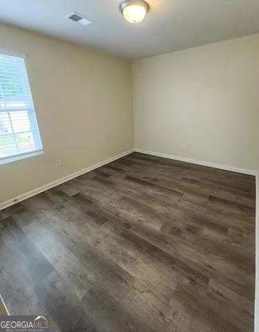 a view of a room with wooden floor and windows