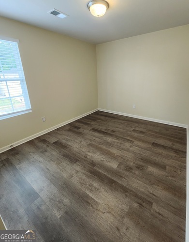 335 Freeman Circle Villa Rica, GA 30180 - Photo 8 of 12 an empty room with wooden floor and windows