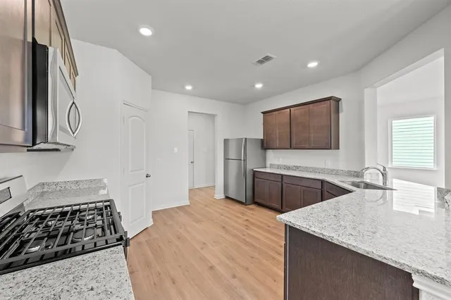 a kitchen with stainless steel appliances granite countertop a sink and a stove