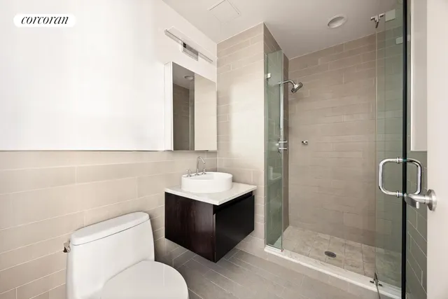a bathroom with a toilet sink vanity and shower