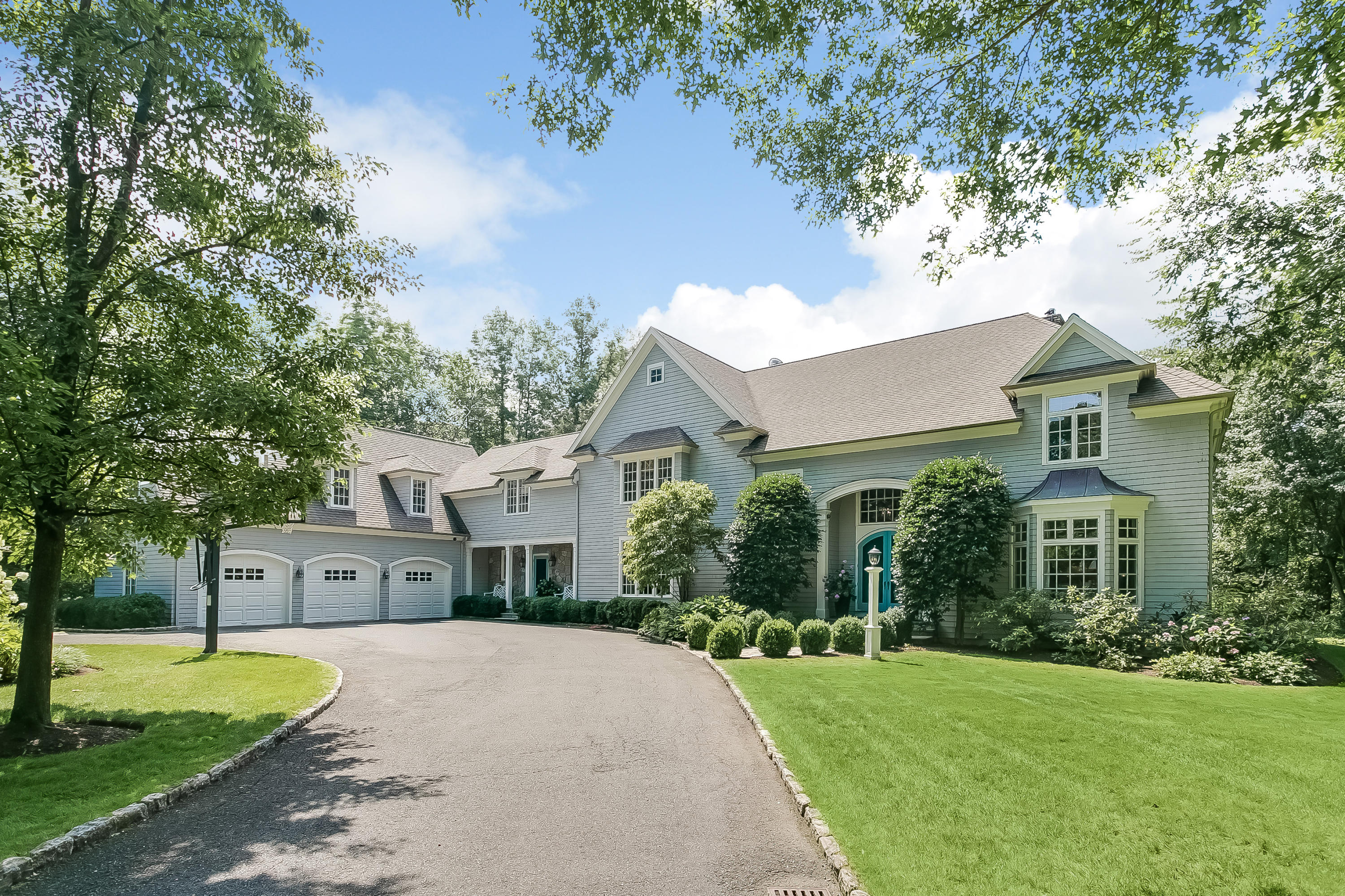 a front view of a house with a garden and trees