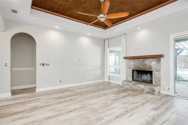a view of a livingroom with a fireplace a ceiling fan and closet area