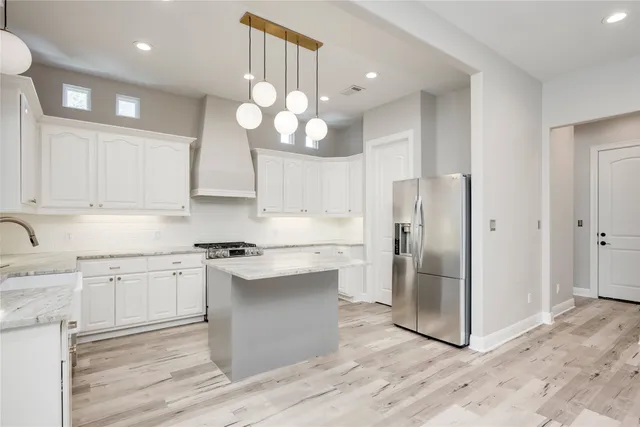 a kitchen with stainless steel appliances granite countertop a stove a sink and a refrigerator