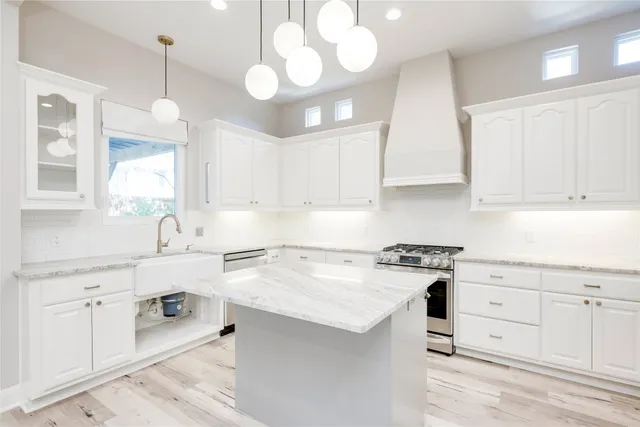 a kitchen with a stove a sink and cabinets