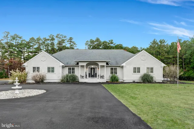 a view of house with a big yard plants and large trees