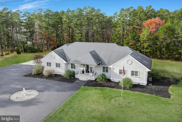 a aerial view of a house next to a yard and trees