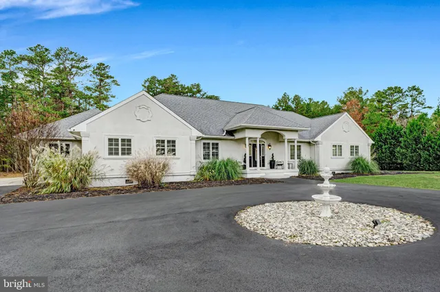 a front view of a house with a yard and trees