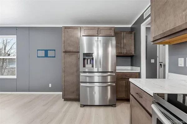 a kitchen with granite countertop stainless steel appliances a refrigerator and wooden floor