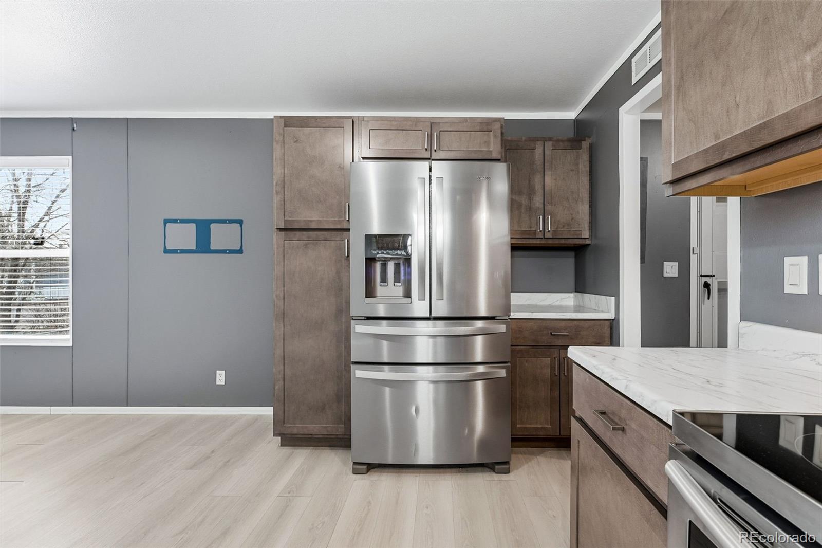 12205 Perry Street, Unit 271 Broomfield, CO 80020 - Photo 12 of 34 a kitchen with granite countertop stainless steel appliances a refrigerator and wooden floor