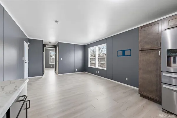 a view of an empty room with window and wooden floor