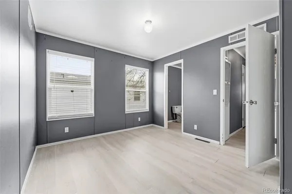 a view of an empty room with window and closet area