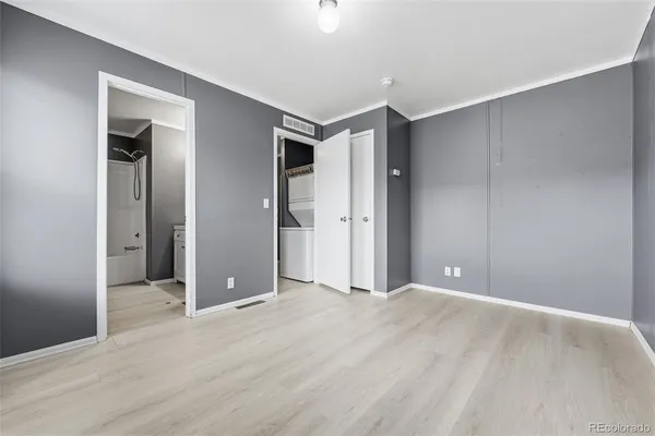 a view of an empty room with wooden floor