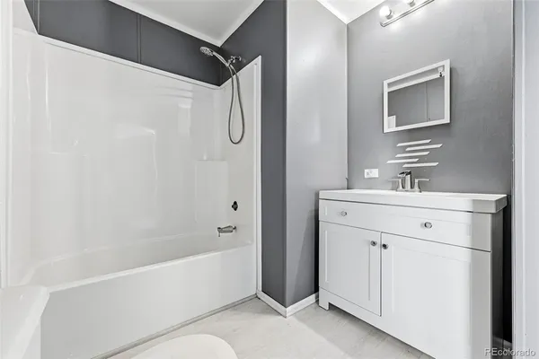 a bathroom with a bathtub a mirror a vanity and a sink