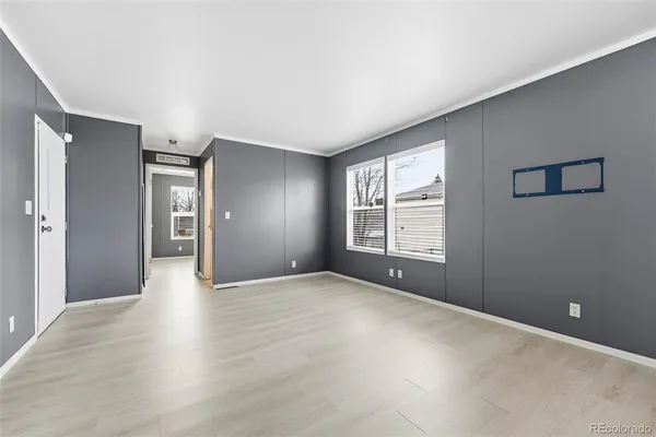 a view of an empty room with window and wooden floor