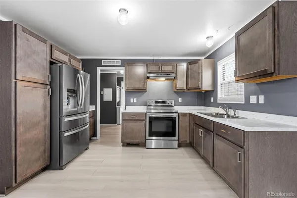 a kitchen with stainless steel appliances granite countertop a refrigerator stove and sink