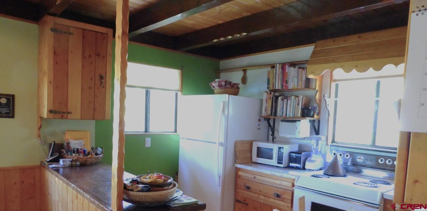 21550 2300th Road Cedaredge, CO 81413 - Photo 13 of 35 a kitchen with a refrigerator and cabinets