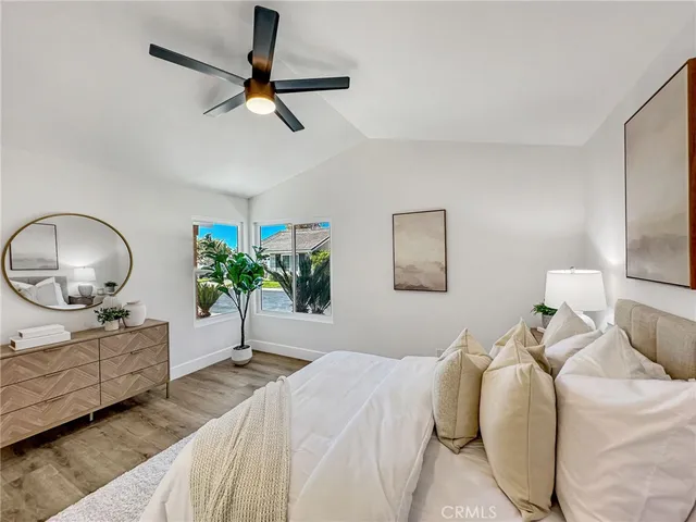a bedroom with a bed potted plant and a chandelier