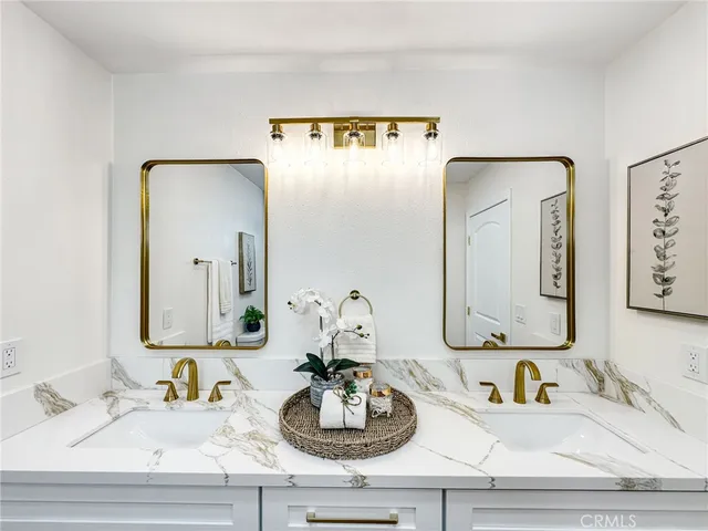 a bathroom with double vanity sinks and a mirror