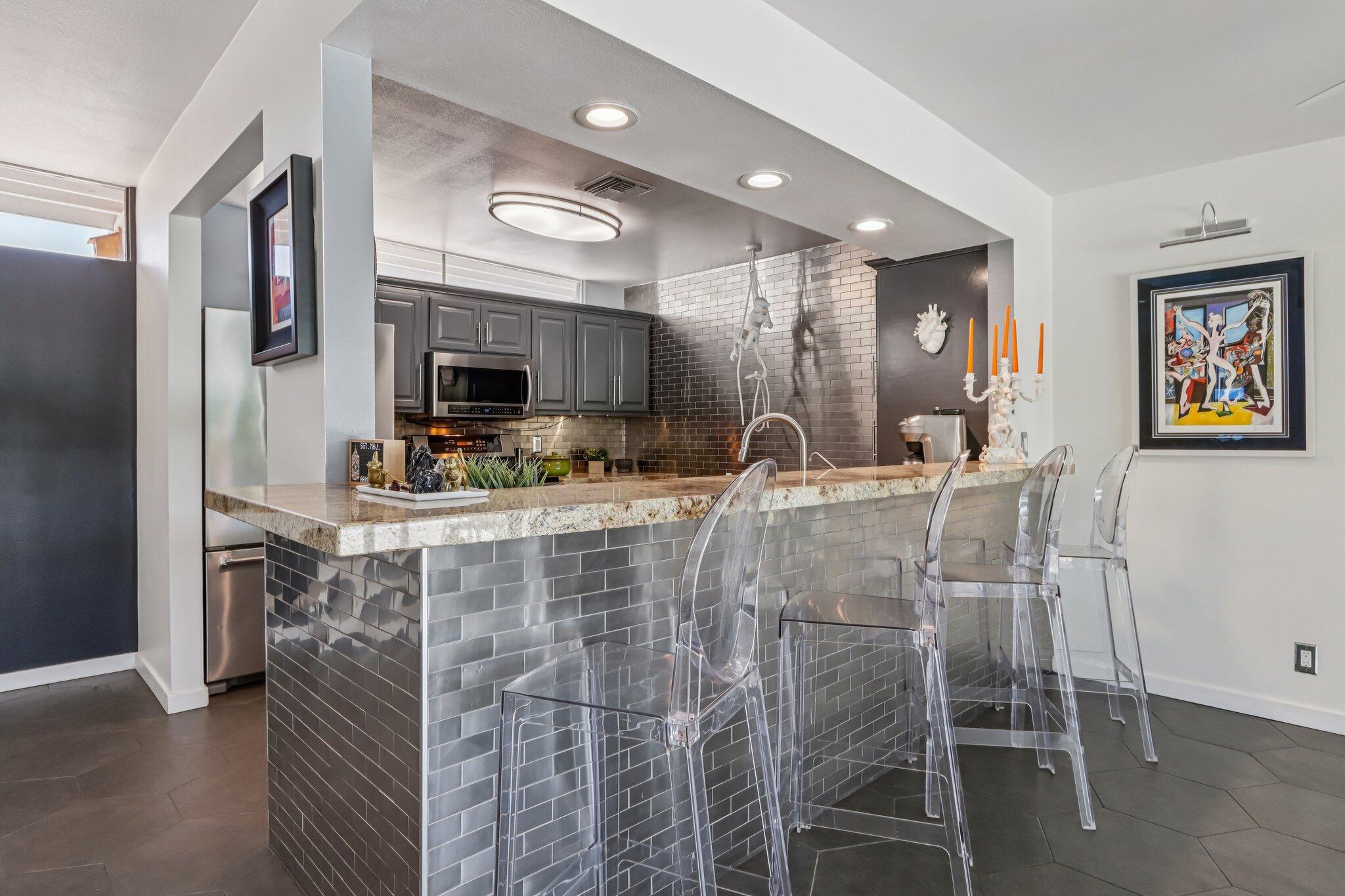 1815 West Nicola Road Palm Springs, CA 92262 - Photo 13 of 30 a kitchen with stainless steel appliances kitchen island granite countertop a refrigerator and microwave