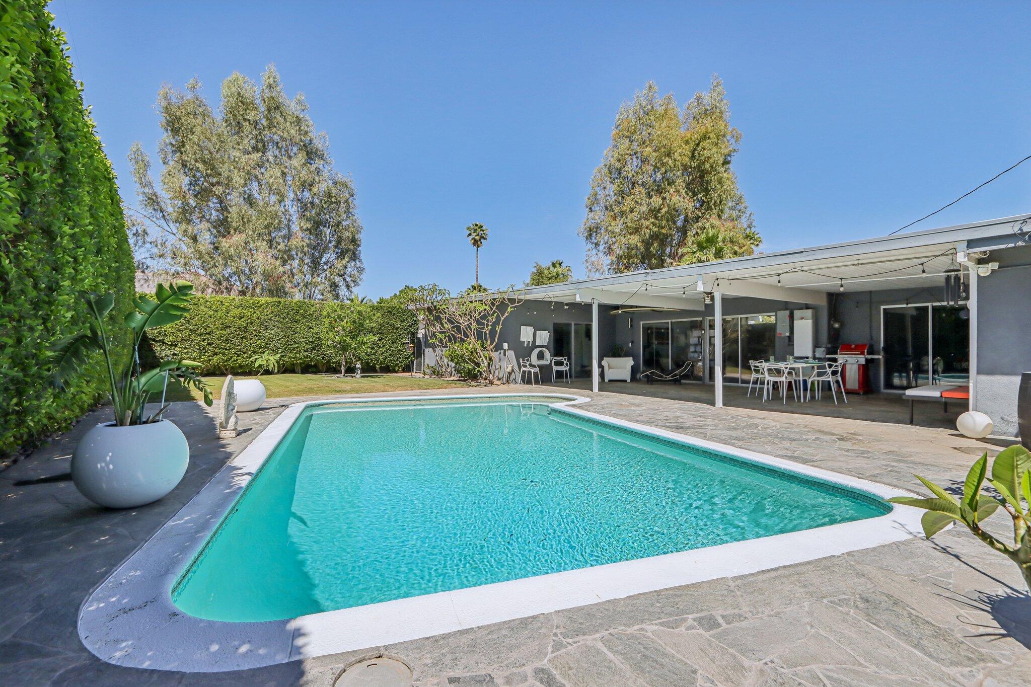 1815 West Nicola Road Palm Springs, CA 92262 - Photo 29 of 30 a view of a white house with a swimming pool and a yard