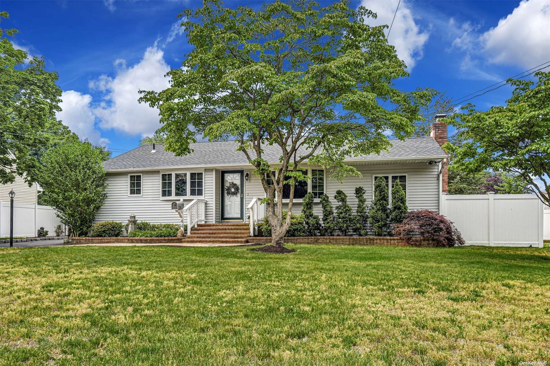 a front view of a house with a yard and trees