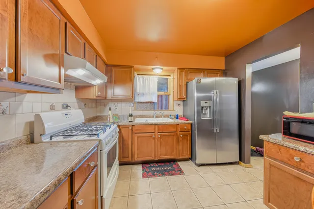 a kitchen with stainless steel appliances granite countertop a refrigerator and a stove