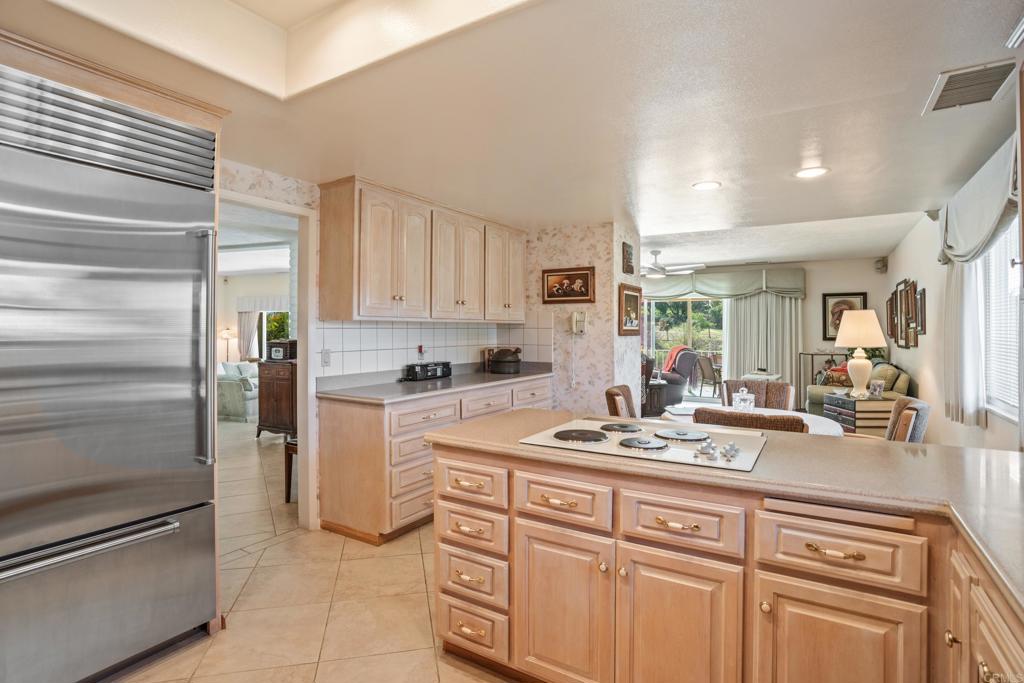 10951 Rim Road Escondido, CA 92026 - Photo 23 of 55 a kitchen with a refrigerator and white cabinets