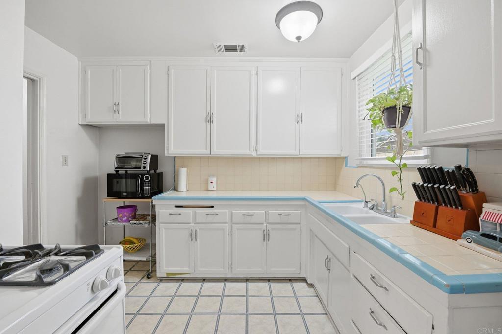 6974 Capistrano Way Riverside, CA 92504 - Photo 8 of 24 a kitchen with granite countertop a sink a stove and cabinets