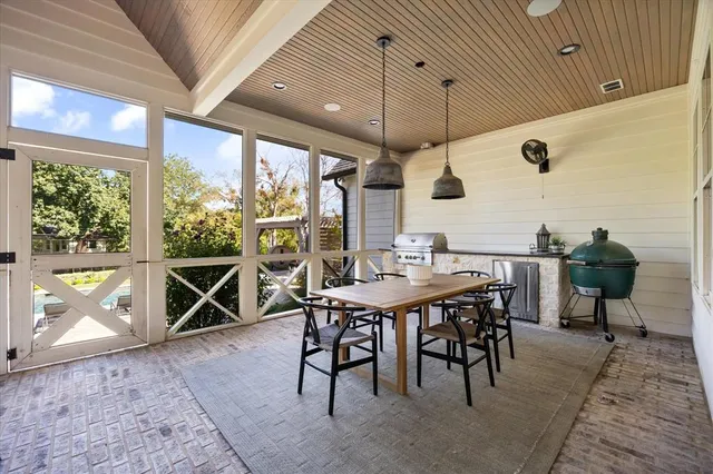 a patio with a table and chairs and a barbeque