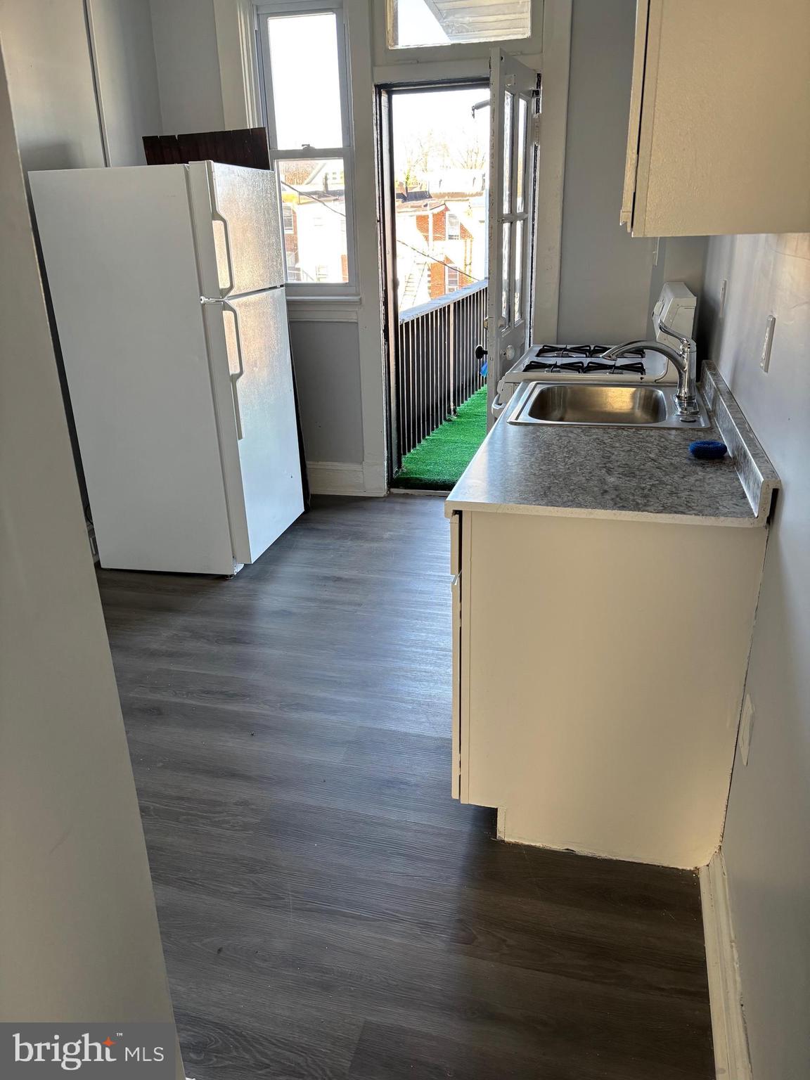 2456 Keyworth Avenue, Unit 2 Baltimore, MD 21215 - Photo 3 of 9 a kitchen with wooden floors and white appliances