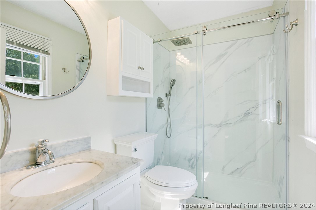 5809 Waldwick Road Fayetteville, NC 28311 - Photo 19 of 33 a bathroom with a sink a toilet and shower