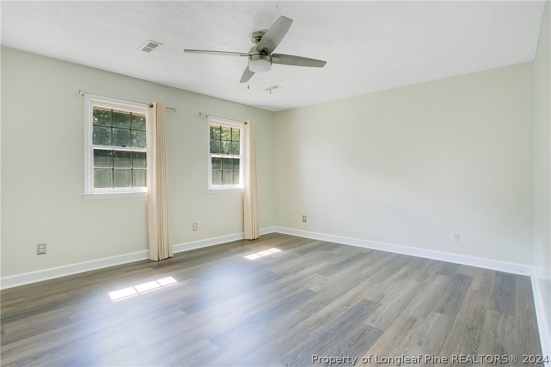 5809 Waldwick Road Fayetteville, NC 28311 - Photo 21 of 33 an empty room with wooden floor and windows