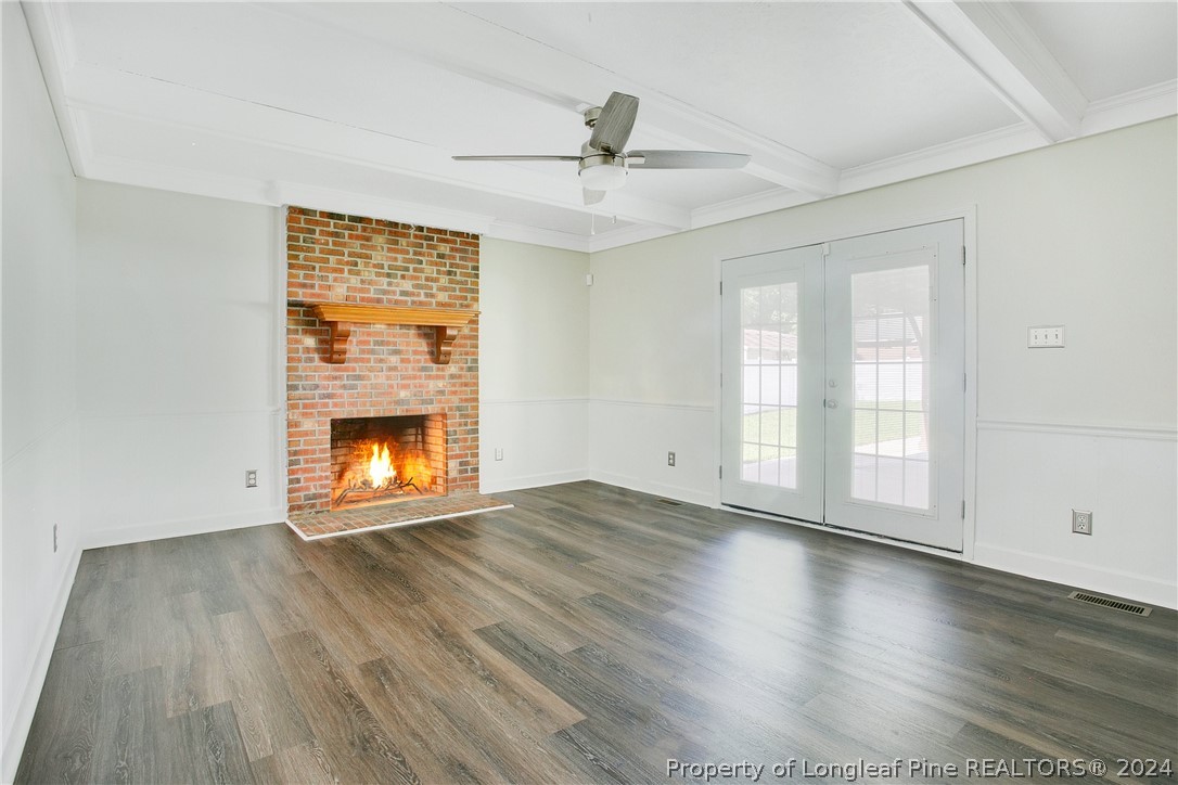 5809 Waldwick Road Fayetteville, NC 28311 - Photo 5 of 33 an empty room with wooden floor fireplace and windows