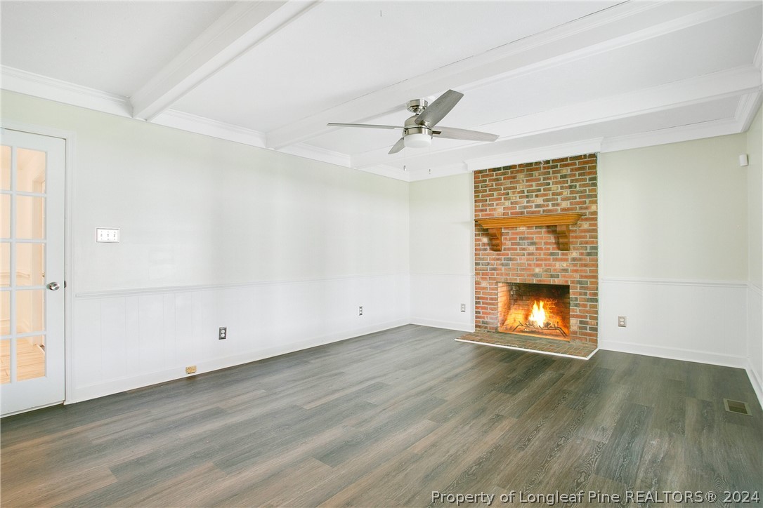 5809 Waldwick Road Fayetteville, NC 28311 - Photo 6 of 33 an empty room with wooden floor fireplace and windows