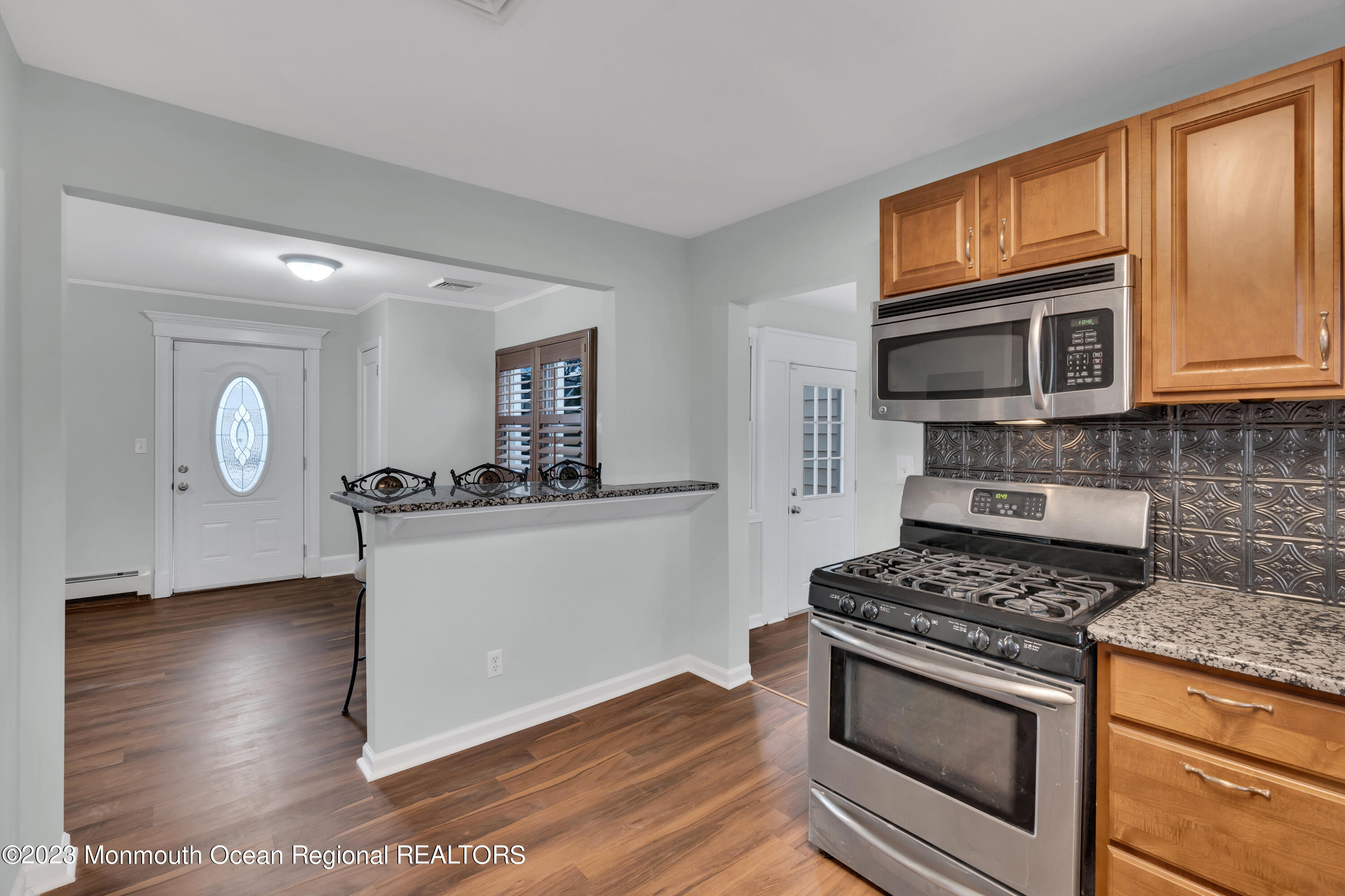 1007 Beaver Dam Road Point Pleasant, NJ 08742 - Photo 17 of 45 a kitchen with granite countertop wooden cabinets stainless steel appliances and a wooden floor