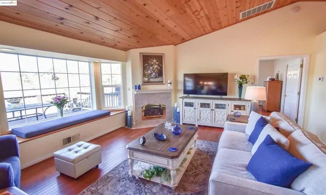 a living room with furniture a flat screen tv and a window