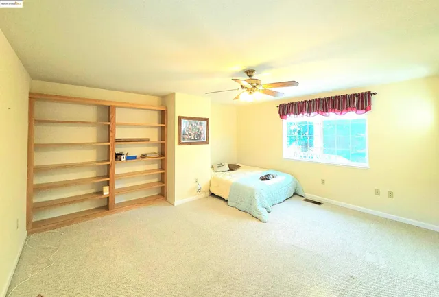 a spacious bedroom with a bed and a window