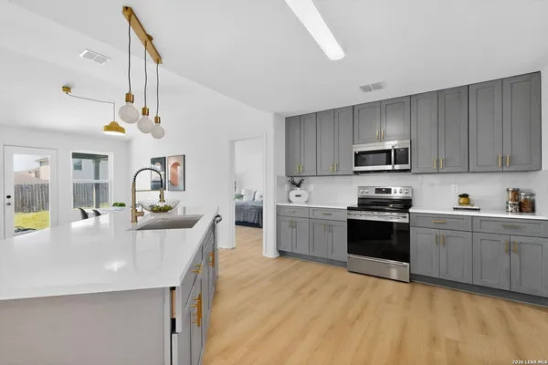a kitchen with stainless steel appliances granite countertop a sink a stove top oven a counter space and cabinets