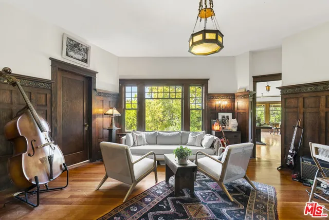 a view of a dining room and livingroom with furniture wooden floor a chandelier