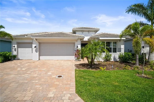 a front view of a house with a yard and potted plants