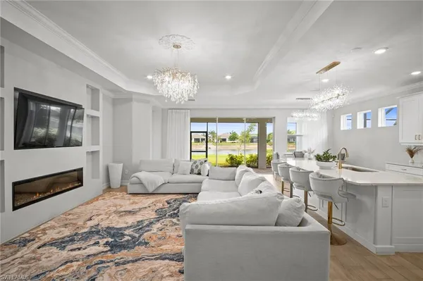 a living room with furniture a chandelier and a fireplace