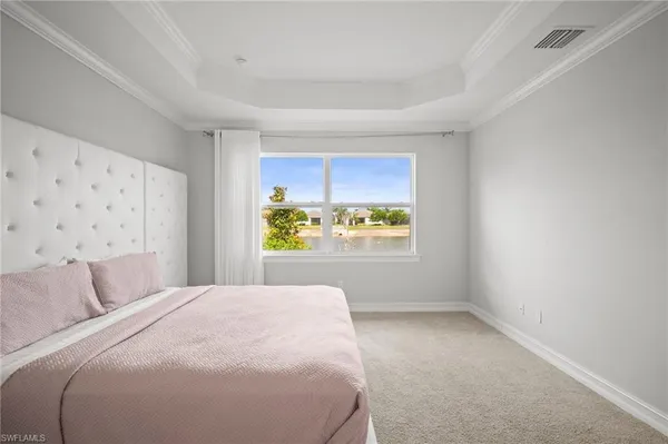 a large white bed in a room next to a window