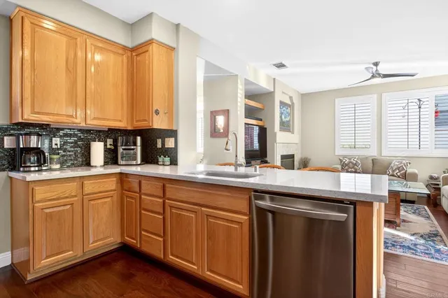 a large kitchen with stainless steel appliances a window and wooden floor