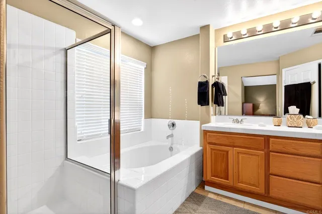 a bathroom with a toilet a sink a mirror a shower and vanity