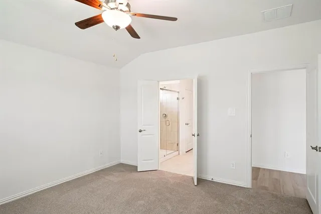 an empty room with closet and a chandelier fan