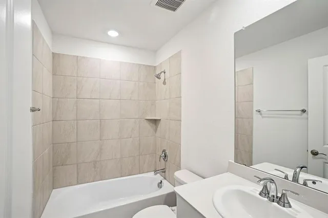 a bathroom with a bathtub shower sink and a toilet