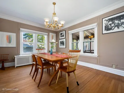 a view of a dining room with furniture a chandelier and wooden floor
