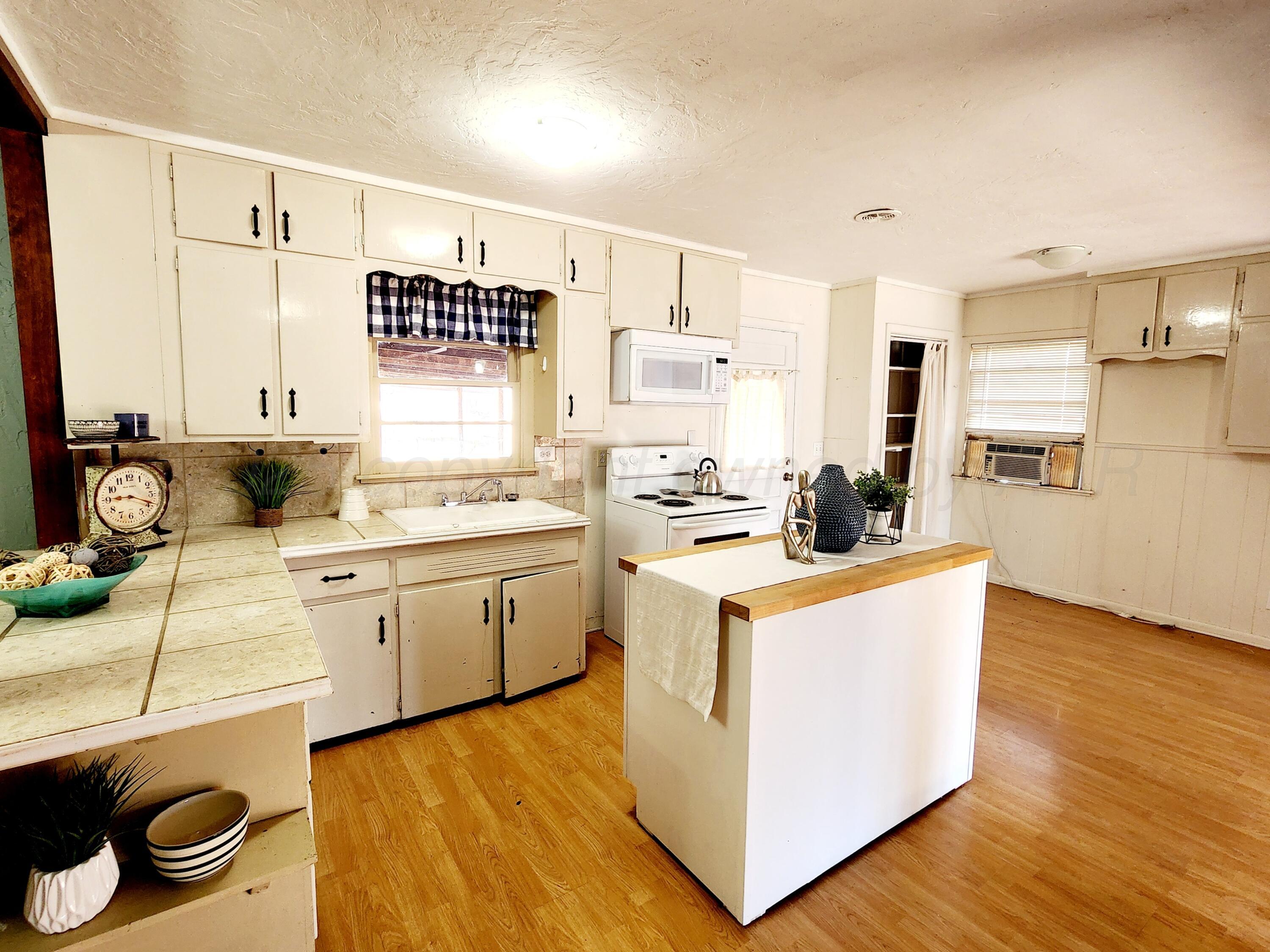 3320 Lynette Drive Amarillo, TX 79109 - Photo 4 of 19 a kitchen with wooden floor and white appliances