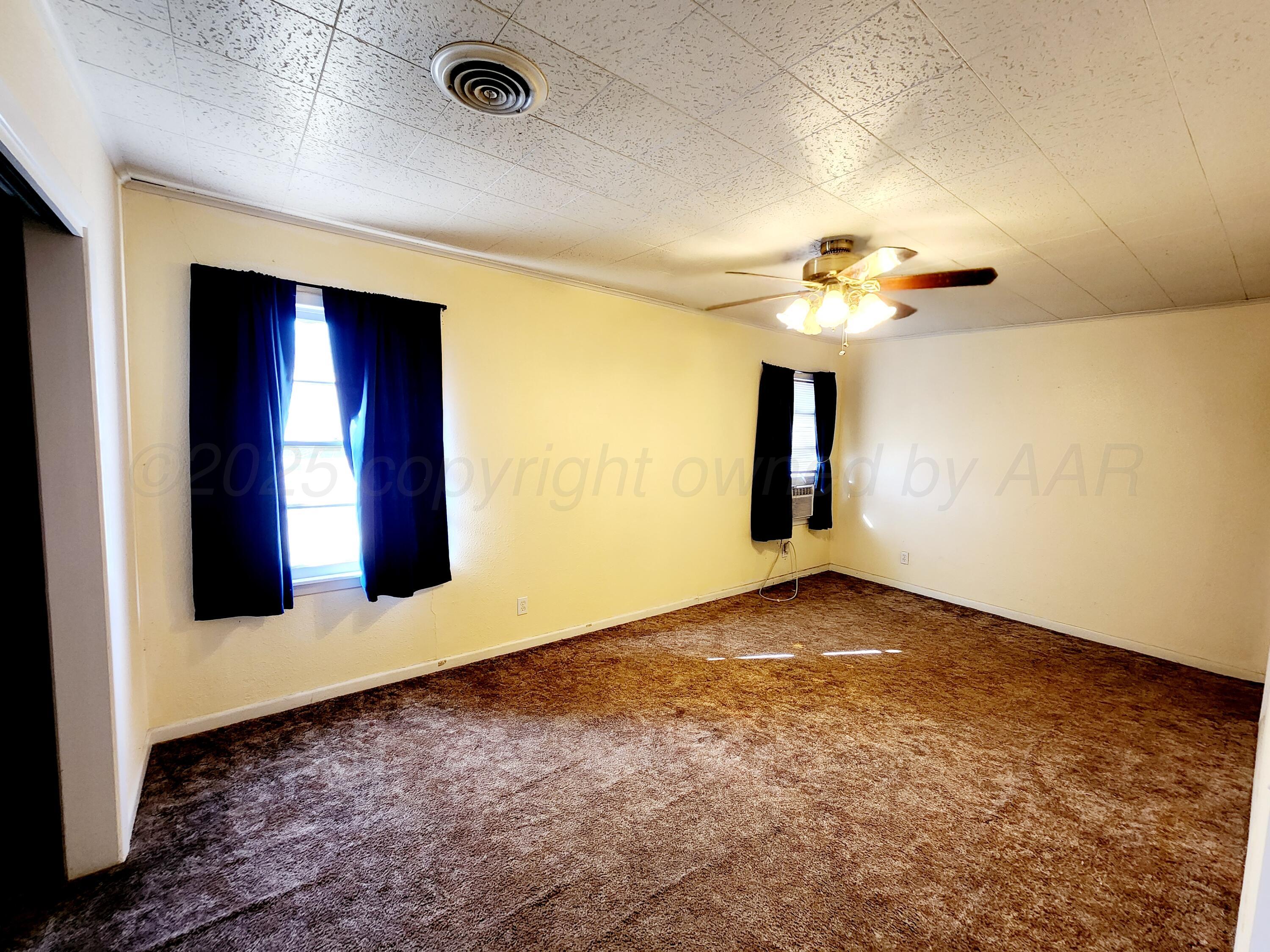3320 Lynette Drive Amarillo, TX 79109 - Photo 10 of 19 a view of an empty room with window and wooden floor