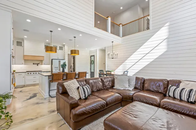 a view of a white house with a big yard and potted plants